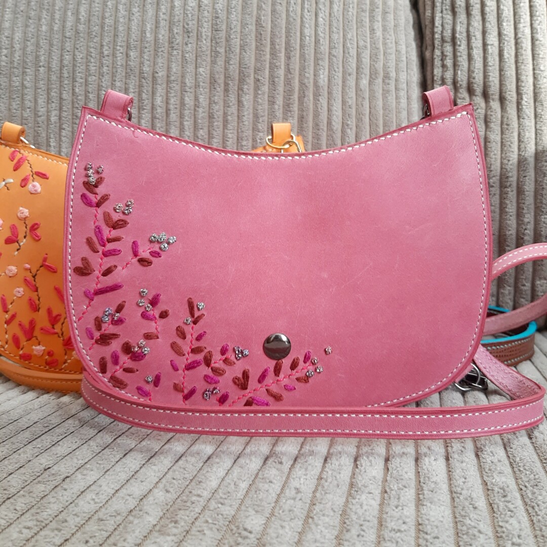 Petit Sac Adoré de couleur rose. Rabat brodé à la main avec des motifs fleuris. Cuir touché velours
