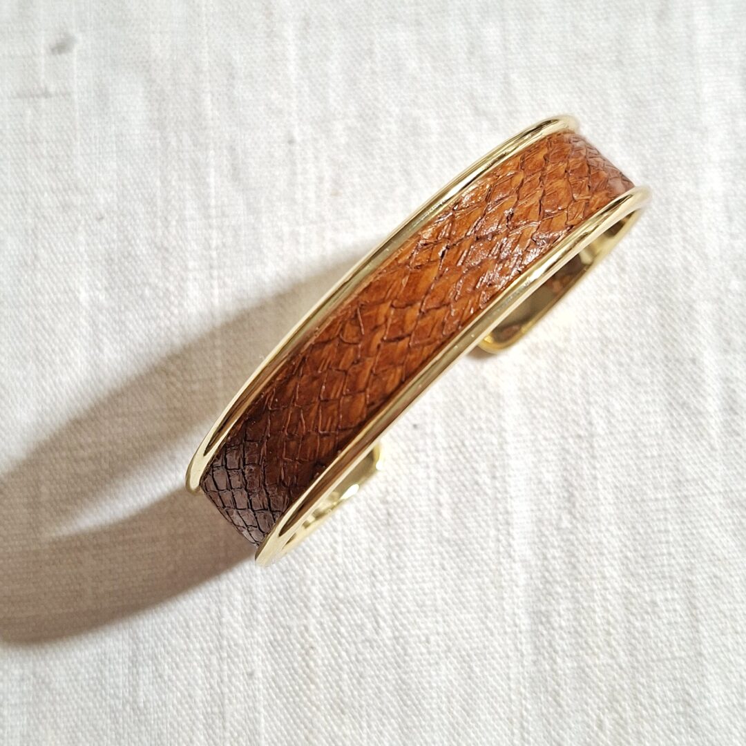 bracelet manchette en métal doré et cuir de saumon marron vernis brillant. Le bracelet est réglable à votre poignet. Pièce unique