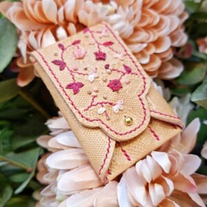 Étui à aiguilles en cuir tannage végétal embossé d'un motif dentelle. Brodé main sur son rabat de motifs floraux et rehaussés de perles de rocailles.
