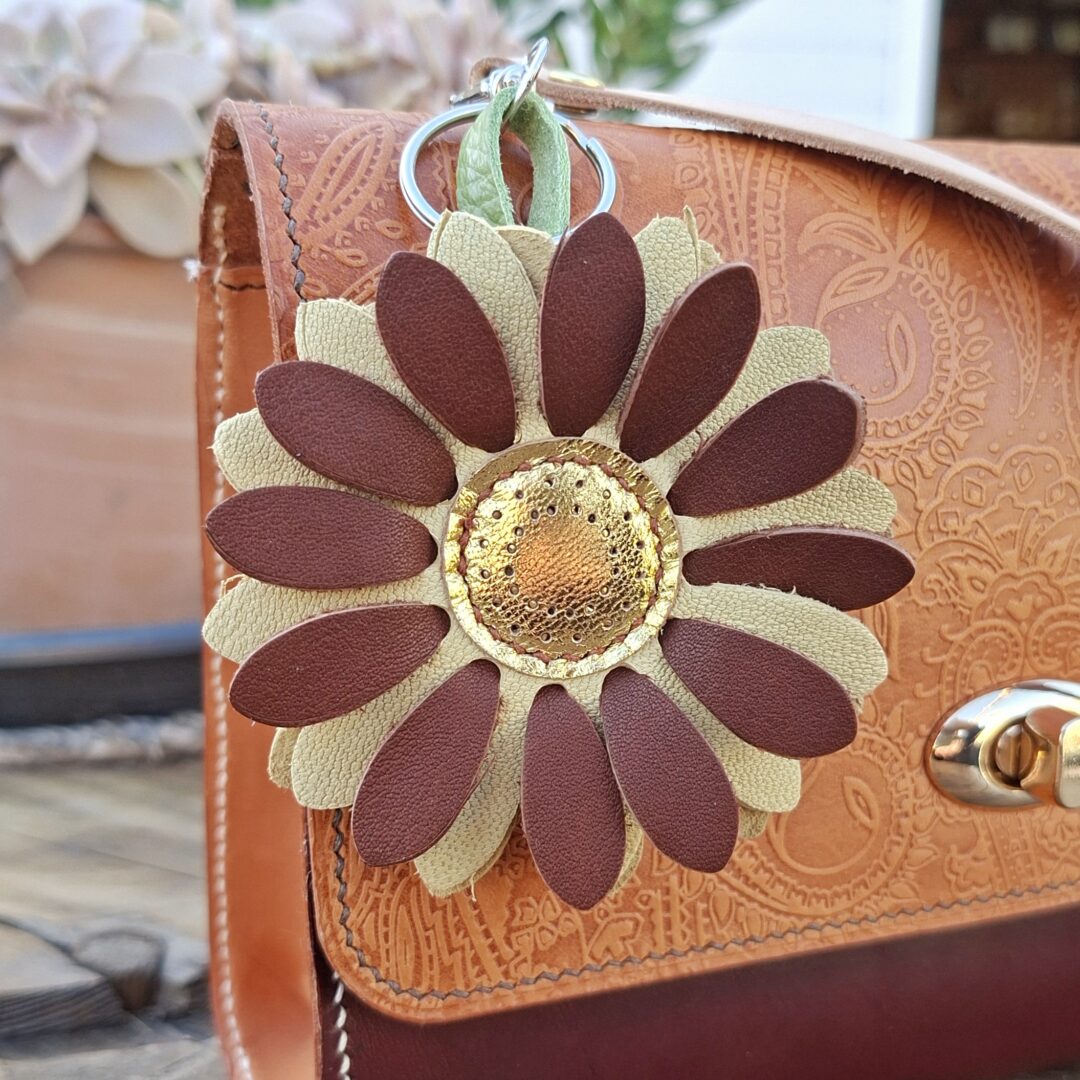 Porte-clés fleur en cuir marron et doré avec cœur métallique et pétales texturés
