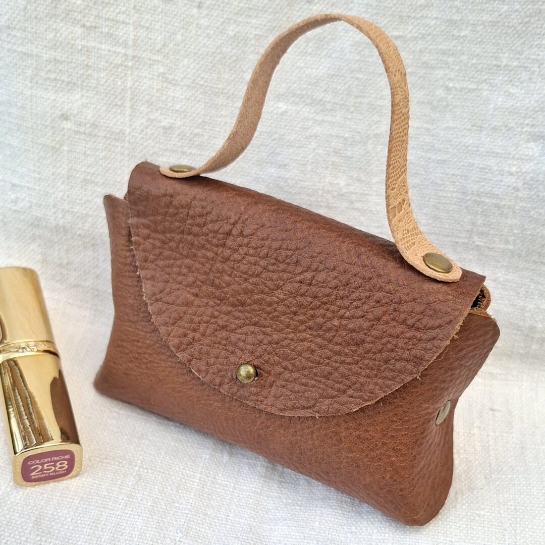Petit sac en cuir grainé pleine fleur marron fabriqué à la main, avec poignée en cuir pleine fleur naturel et fermeture par bouton de col.