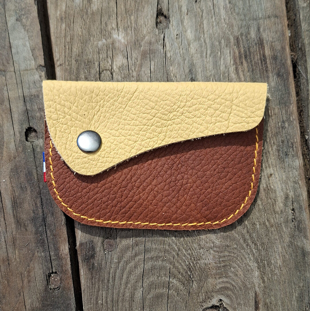 Porte-monnaie artisanal en cuir pleine fleur marron et jaune avec fermeture par bouton pression métallique et couture au point sellier jaune d'or.