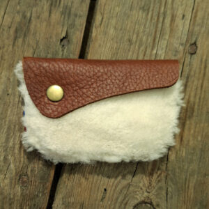 Porte-monnaie artisanal en cuir de mouton blanc à poils et cuir pleine fleur pull-up marron avec bouton pression métallique doré.
