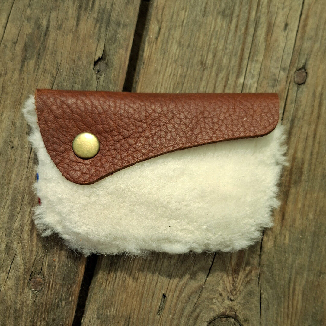 Porte-monnaie artisanal en cuir de mouton blanc à poils et cuir pleine fleur pull-up marron avec bouton pression métallique doré.