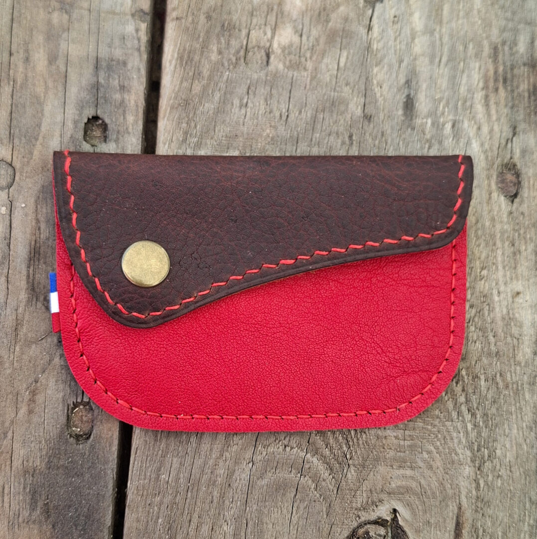 Porte-monnaie artisanal en cuir pleine fleur grainé rouge avec rabat en cuir brun, bouton pression métallique et couture au fil de lin rouge. porte-monnaie en cuir rouge
