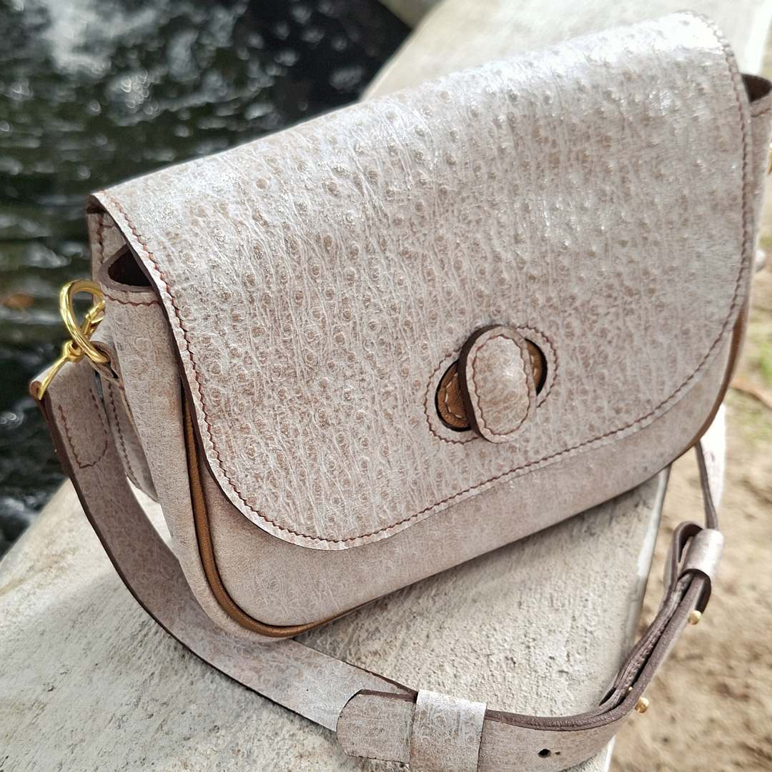 Sac en cuir de chèvre fantaisie imitation autruche avec reflets nacrés et passepoil métallisé bronze. Maroquinerie artisanale